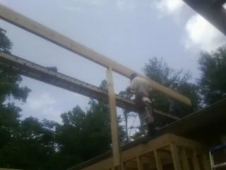 Carpenter setting a ridge beam over a new addition frame — Ice Dam Removal by Roofing Brothers in Muldrow