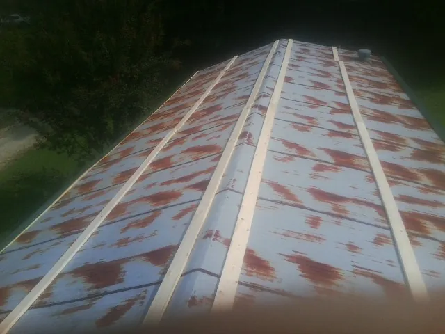 Rusted metal roof panels with new wood purlins before replacement — Storm Damage Roof Repair in Muldrow by Roofing Brothers